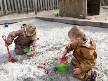 Børn der leger i sandkassen